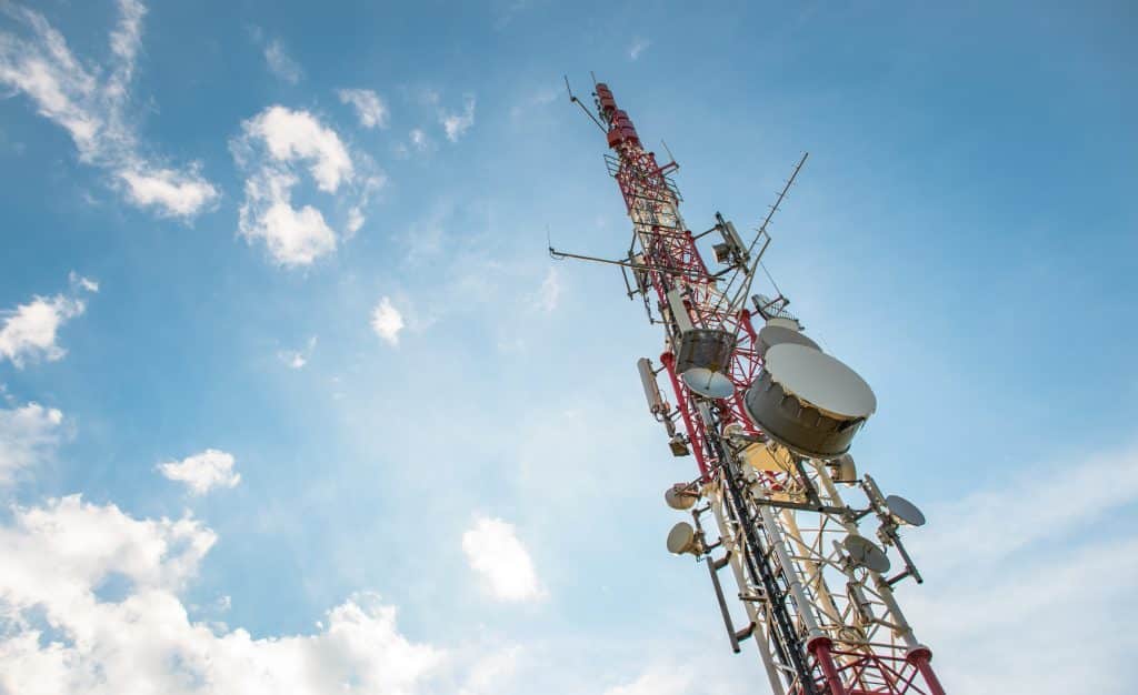 Low angle view of Antenna tower against a blue sky. 5g network cell tower.