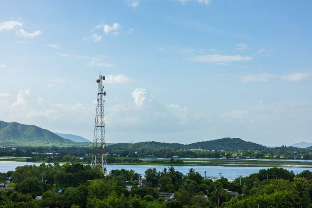 a cell tower for a mobile phone over a rural, forested area in Thailand