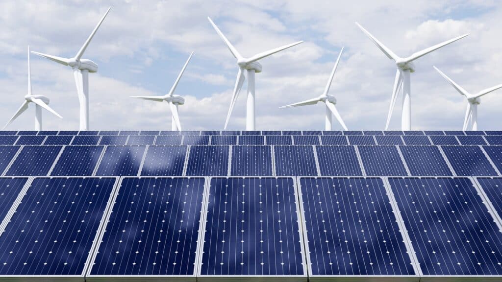 Solar panels and wind turbine on the sky background.