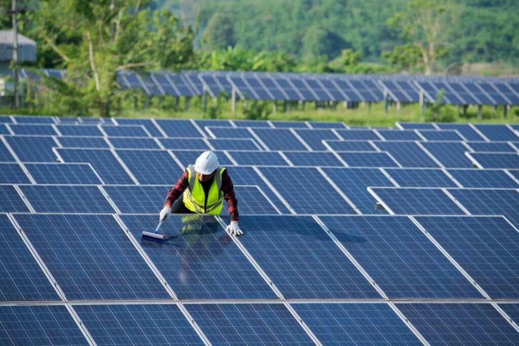 Cleaning Solar Panels By Workers In Uniform Safety At Solar Farm