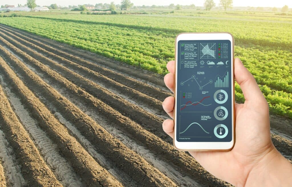 Hand Holds Mobile Phone With Crop Status Analysis Infographics. Quality Control