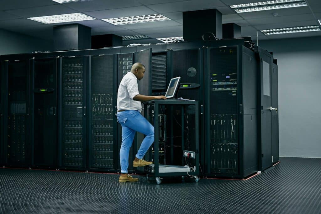 Skilled In All Things It. Shot Of An It Technician Using A Computer While Working In A Data Center.